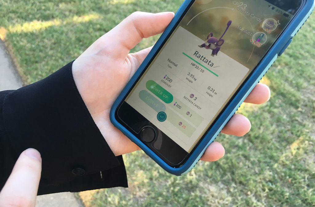 hands holding phone displaying pokemon go app